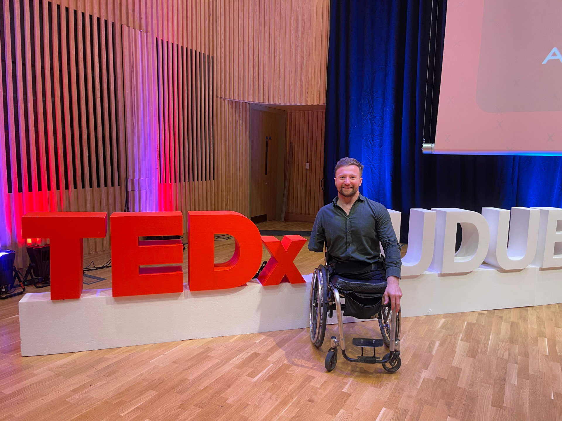 Colin Judge beside the TEDx UCD Dublin stage letters