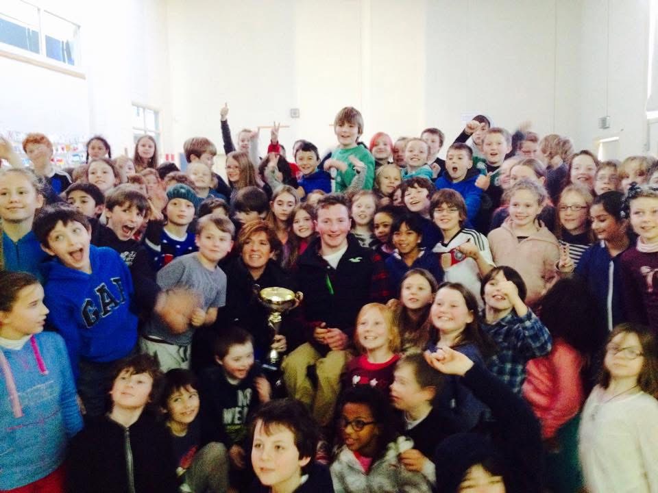 Colin Judge celebrating with primary school pupils and a trophy